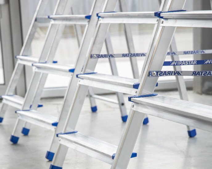 How are the steps of stepladders and the rungs of ladders attached to the sidewalls?